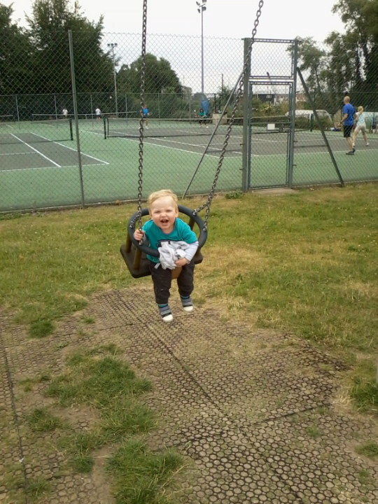 Alfie enjoying himself on the swings at Kingston Fields.