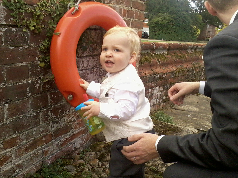 The other page boy Alfie with a drink in his hand.