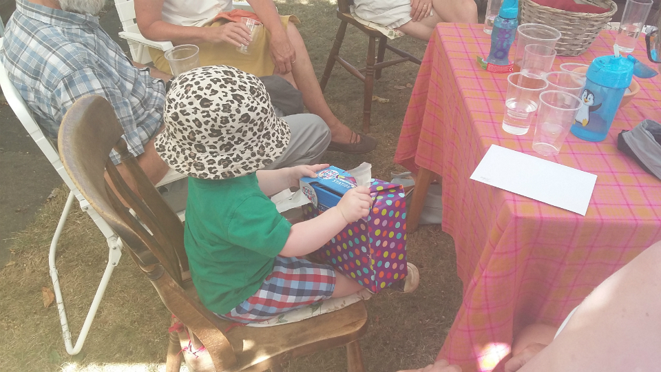 Joshua opening a birthday present at the Offton BBQ.