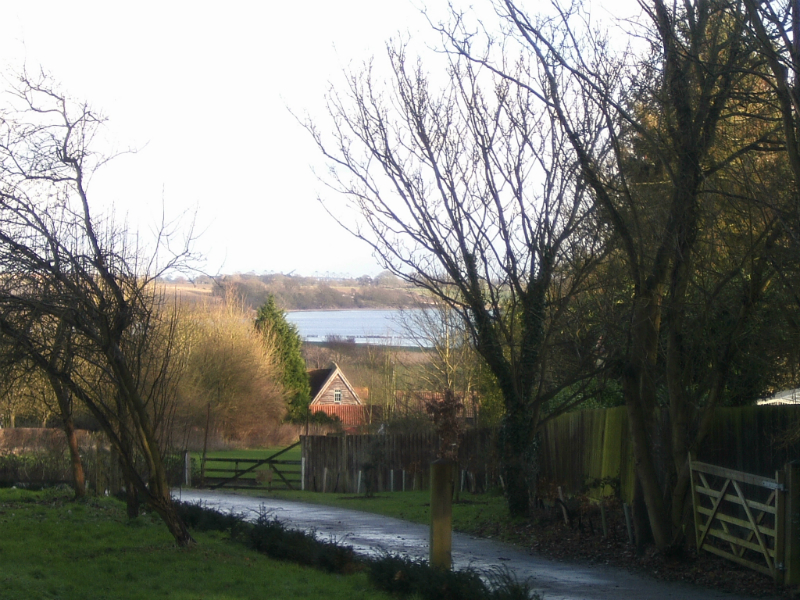 The view from outside Stutton church, down to The River Stour, and the cranes of Felixstowe Docks in the background.